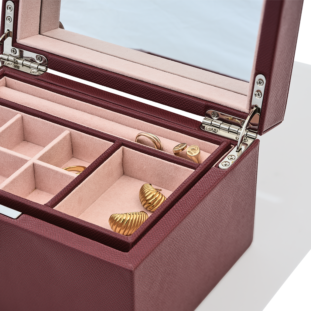 Jewelry box with gold earrings inside on a light blue background