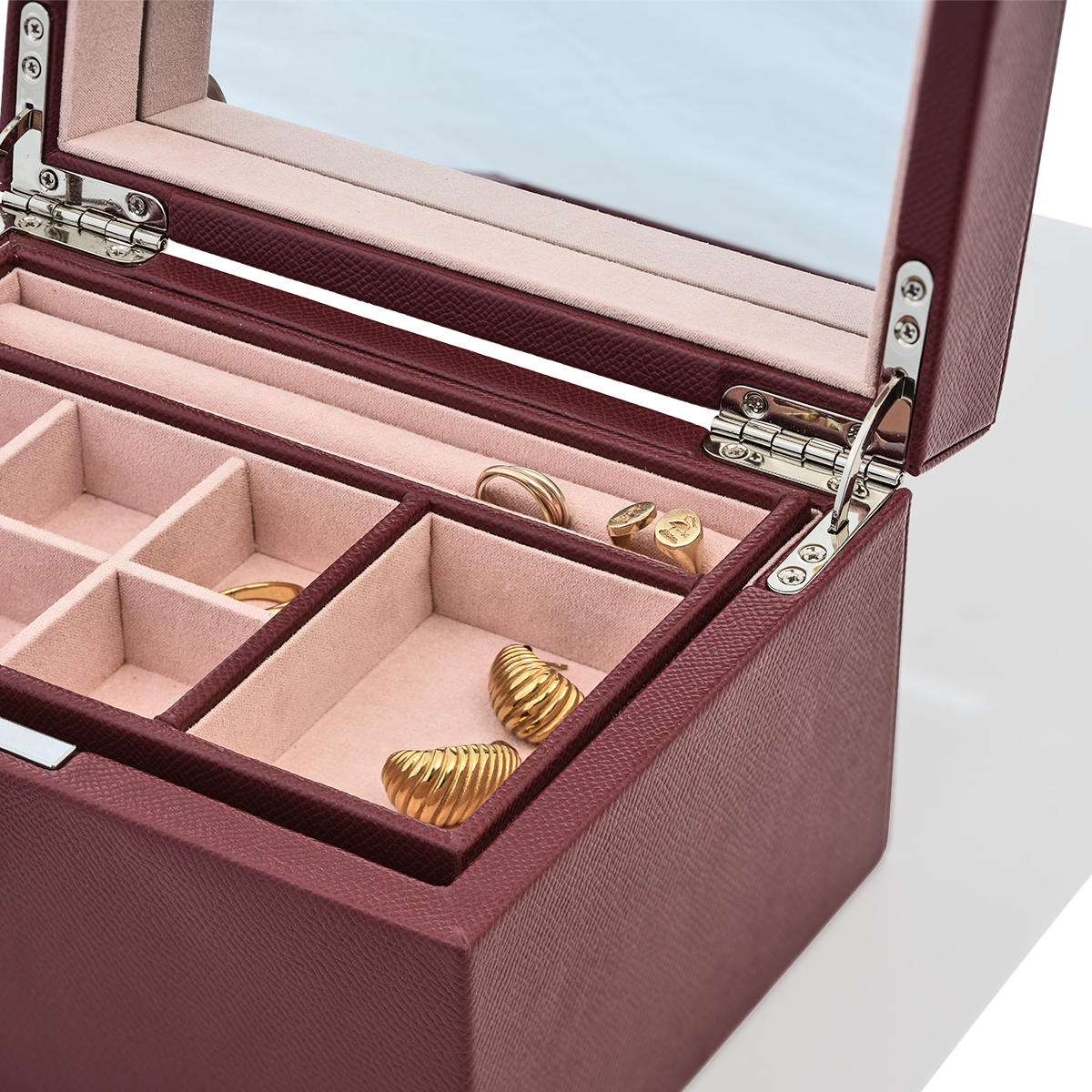 Jewelry box with gold earrings inside on a light blue background