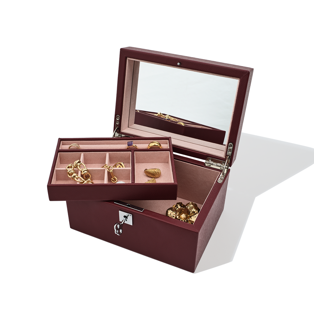 Open jewelry box with gold jewelry on a white background