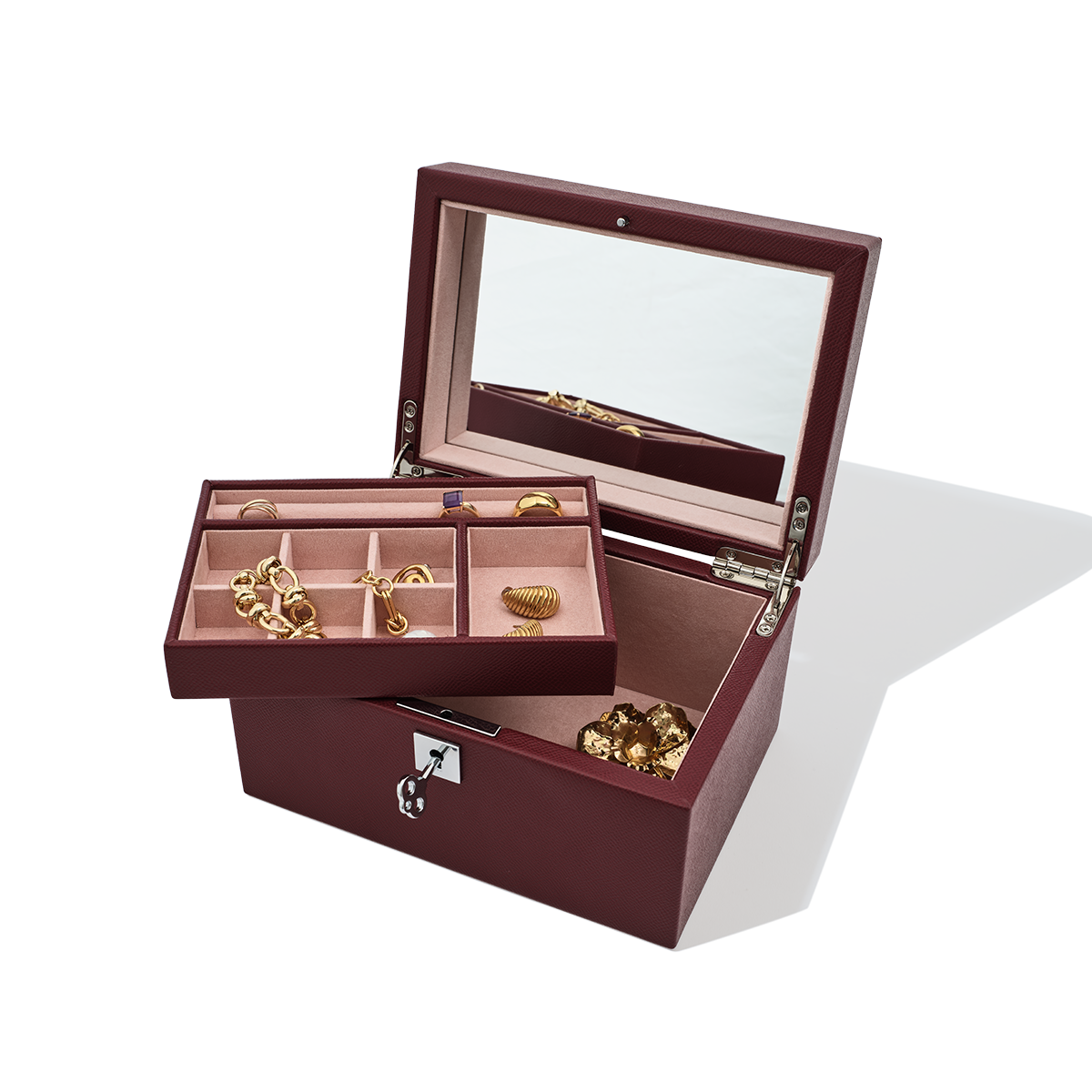 Open jewelry box with gold jewelry on a white background