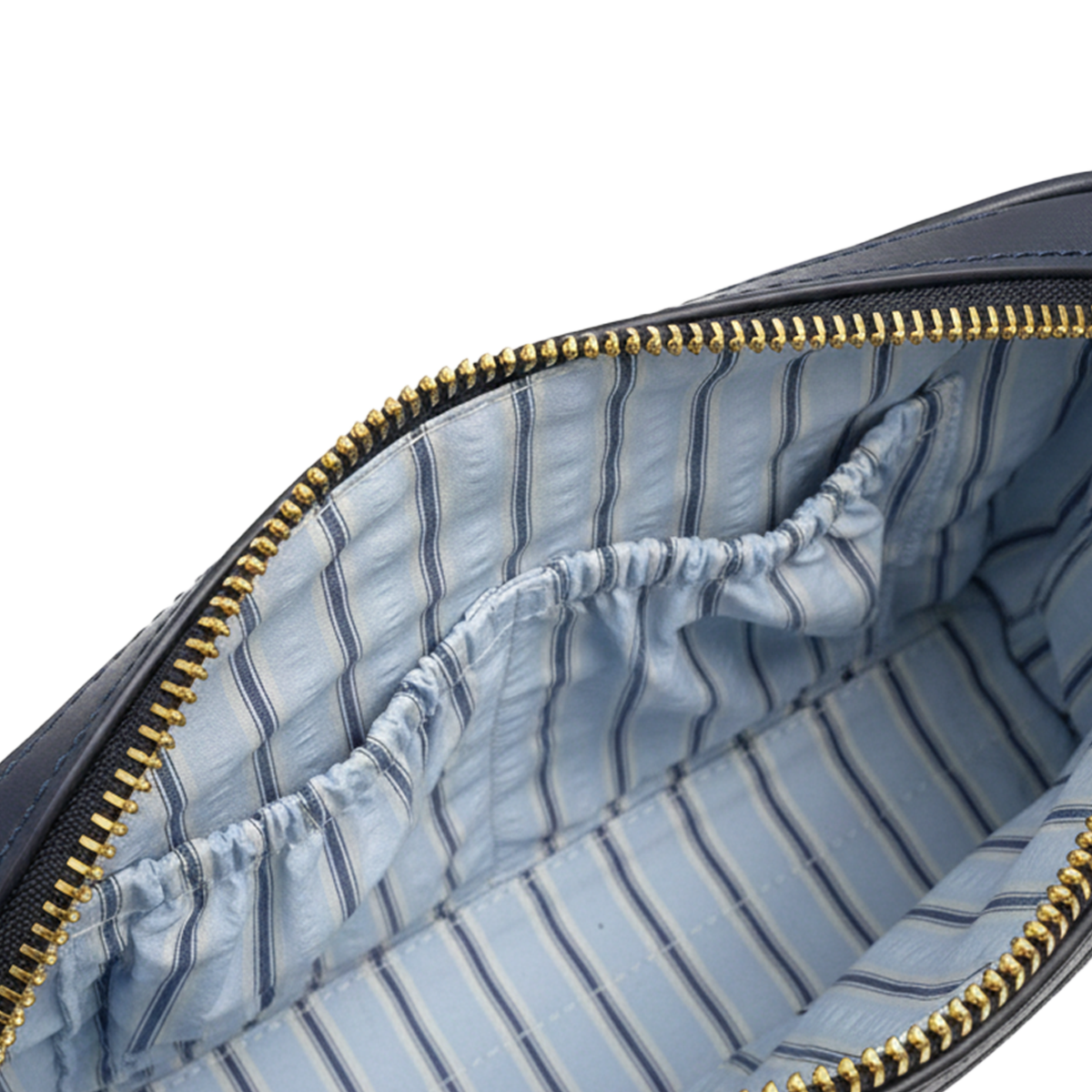 Close-up of a blue striped interior of a bag with gold zipper.